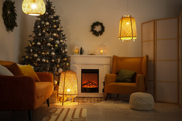 Interior of living room with fireplace, Christmas tree and glowing lamps in evening