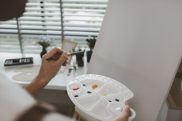 an artist is sitting in his own painting studio with his various painting tools, which is canvas,...