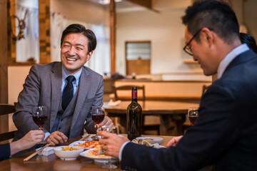 飲み会で盛り上がって爆笑するビジネスマン
