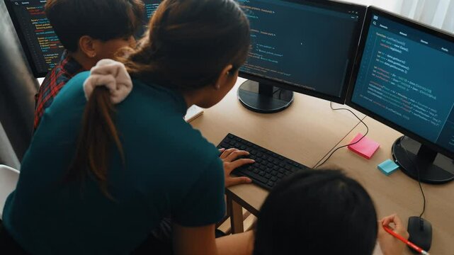 Slow motion back end software developer engineer for computer programming working together on debugging writing computing code, solving complex algorithms display on monitor in office. Burgeoning