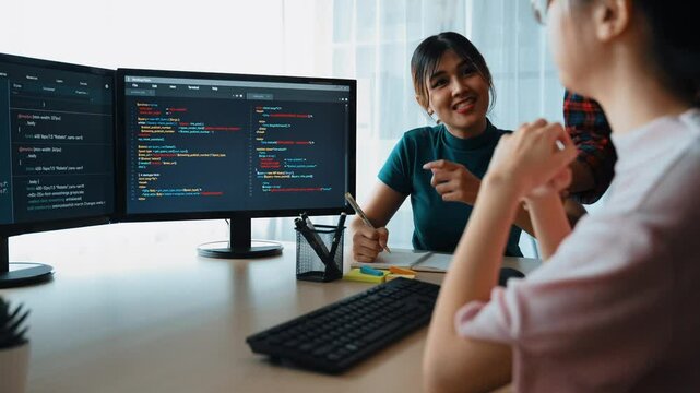 Slow motion back end software developer engineer for computer programming working together on debugging writing computing code, solving complex algorithms display on monitor in office. Burgeoning