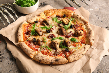 Baking paper of tasty pizza with mushrooms and skeleton hands for Halloween celebration on grey background
