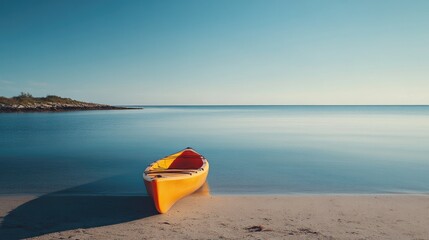 A kayak resting on the shore by the sea, with calm blue waters and a clear sky stretching out toward the horizon.