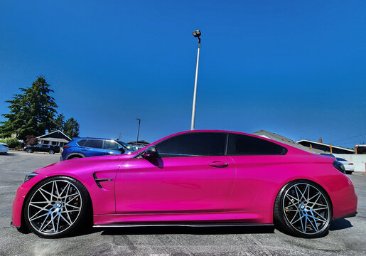 Seattle, WA, USA -July 19, 2024 : BMW F82 M4 Competition pink color side view. BMW F82 M4 is the sport version of BMW car.