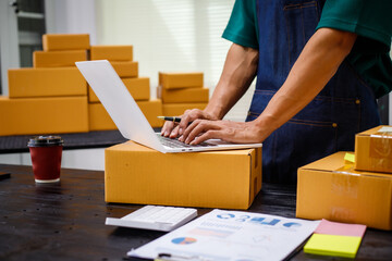 close-up of a man's hands working meticulously with a cardboard box on wooden desk, representing an online seller effort to pack products, successful business operations and customer satisfaction.