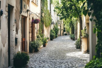 Fototapeta premium A cobblestone street lined with old buildings and lush greenery in a quaint European town.