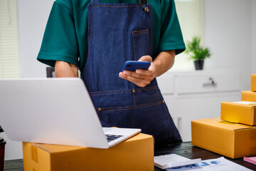 close-up of a man's hands working meticulously with a cardboard box on wooden desk, representing an online seller effort to pack products, successful business operations and customer satisfaction.