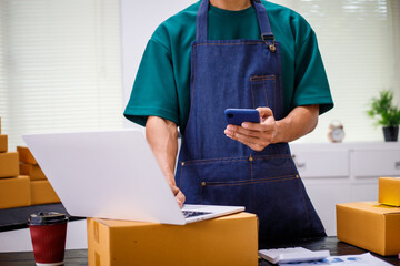 close-up of a man's hands working meticulously with a cardboard box on wooden desk, representing an...