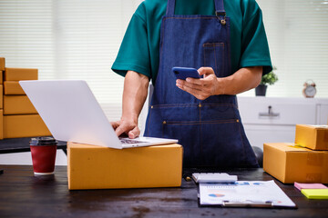 close-up of a man's hands working meticulously with a cardboard box on wooden desk, representing an...