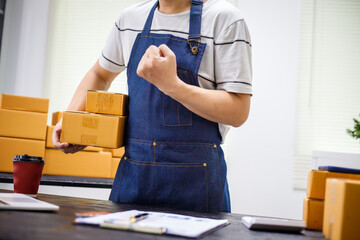 close-up of a man's hands working meticulously with a cardboard box on wooden desk, representing an online seller effort to pack products, successful business operations and customer satisfaction.