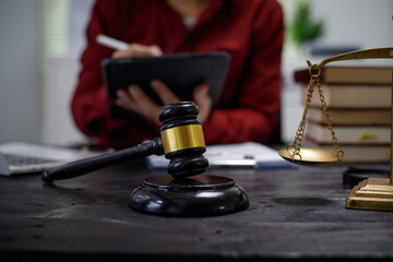 close-up of a lawyer’s hands working at a desk, reviewing legal documents and contracts, with a wooden gavel nearby, symbolizing law, legislation, and the potential complexities of bribery cases.