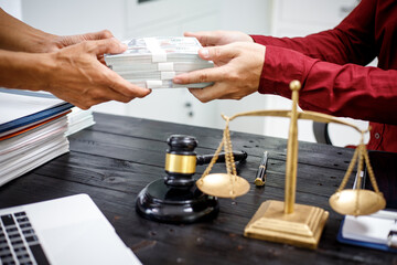 close-up of a lawyer’s hands working at a desk, reviewing legal documents and contracts, with a wooden gavel nearby, symbolizing law, legislation, and the potential complexities of bribery cases.