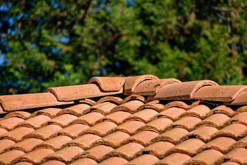 A red clay tile roof shows signs of aging. Close up.