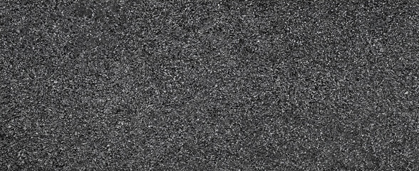 Detailed close-up of dark granular gravel texture, ideal for backgrounds, construction materials, or design elements.