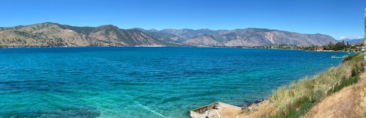A Lake Chelan panoramic landscape showing the incredible blue of the lake with the contrast of the arid hills in the background and a beautiful early summer day_20240623.