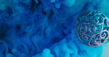 Christmas ornament. Blue color smoke. Sparkling glitter intricate bauble decoration ink water...