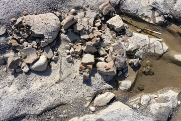 the structure of the rock bottom is a shallow mountain river, a stone shelf, a sunny day