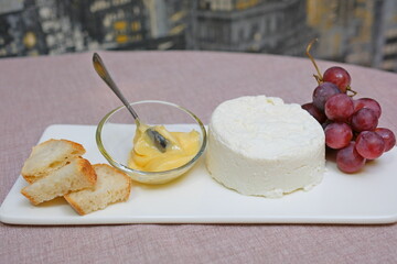 Fresh homemade dairy ricotta cheese, close-up opening white net bag. fresh ricotta cheese with linden white light honey