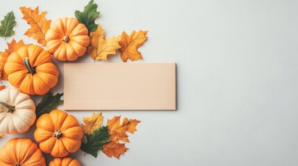 Pumpkins and leaves on a light background with empty space.