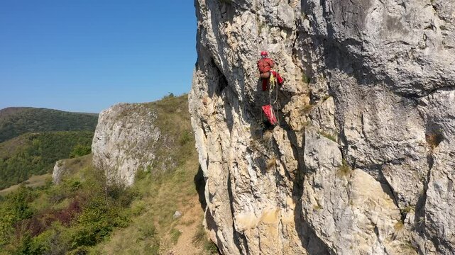 Aerial view of mountain rescuer doing rescue operations hanging on a rope