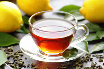 Green tea with lemon, immune booster antivirus drink, hot winter tea on black background, closeup, natural medicine and naturopathy concept