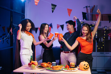 Halloween party with friends in costumes, enjoying drinks, food, and festive decorations. Perfect...