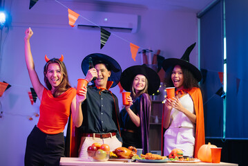 Halloween party with friends in costumes, enjoying drinks, food, and festive decorations. Perfect...