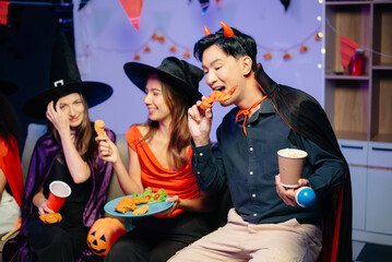 Halloween party with friends in costumes, enjoying drinks, food, and festive decorations. Perfect...
