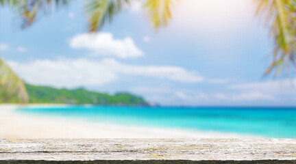 An empty wooden table in the foreground, set against a sunny sea horizon