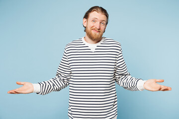Young sad unhappy man he wear striped sweatshirt casual clothes shrugging shoulders looking...