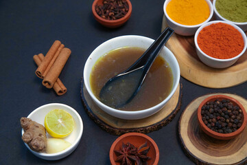 mutton soup, chicken soup, vegetable soup along with onion or creamy onion raita, lemon, Star anise, cinnamon, pepper, clove, chutney, chicken gravy and spices on white bowl