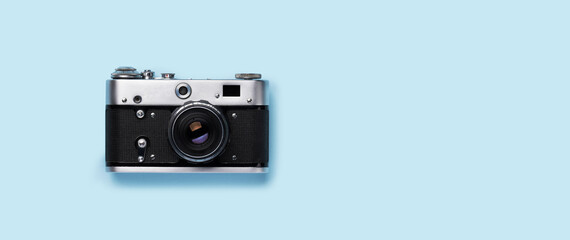 A vintage retro camera placed flat on a bright blue background