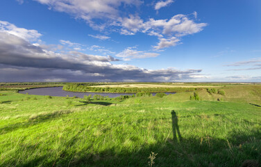 A beautiful, grassy field with a river running through it