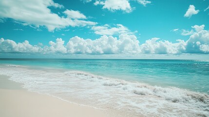 Obraz premium Beautiful white sand beach and calm waves of the turquoise ocean on a sunny day on the background of white clouds in the blue sky. Beautiful colors. Natural landscape 
