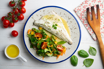 Baked sea bass with lemon sauce. Top view table with decorations.