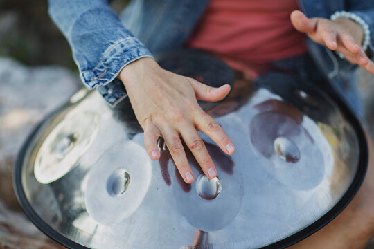 Woman's hands playing handpan drum close-up