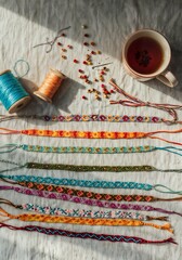 braided bracelets, embroidery threads, and beads with a cup of tea