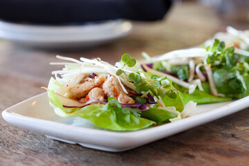 Chicken lettuce wraps garnished with sprouts