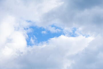 Obraz premium Serene Blue Sky Peeks Through Fluffy White Clouds on Tranquil Afternoon