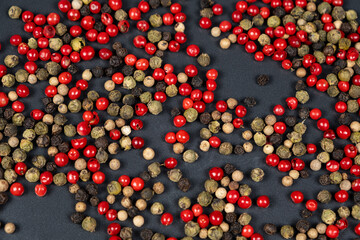 A mixture of different peppercorns white, black, red and green peppers spices.