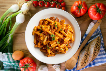 Italian macaroni with chorizo ​​and tomato sauce. Top view table with  decorations.