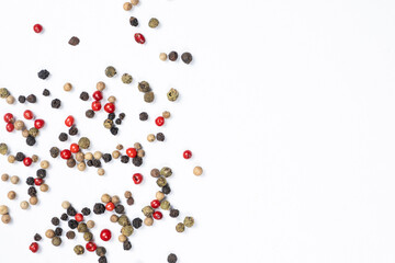 Red, green, white and black peppercorns on a white background, copy space for text