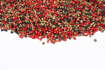 Red, green, white and black peppercorns on a white background