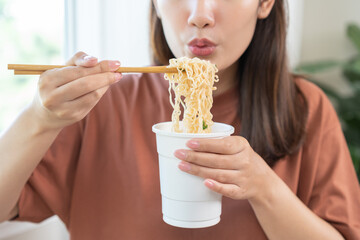 Happy temptation, attractive asian young student woman, cute girl using chopsticks eating instant...
