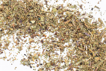 Dry basil spice seasoning macro texture on white background.