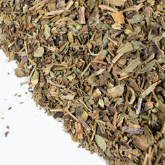 Dry basil spice seasoning macro texture on white background.