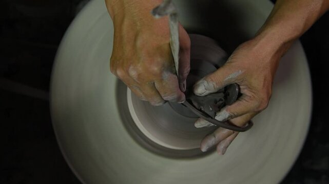 Using a potter's wheel to shaping the cray body by shaped tool to create fine details of the hollow shape