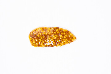 Smear of French Dijon mustard on a white background, top view