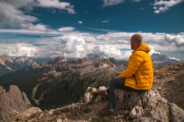 Naklejka premium Hiker enjoys the view from Lagazuoi mountain over the italian Dolomites.