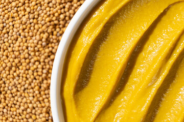 Mustard sauce and dry mustard seeds, top view.